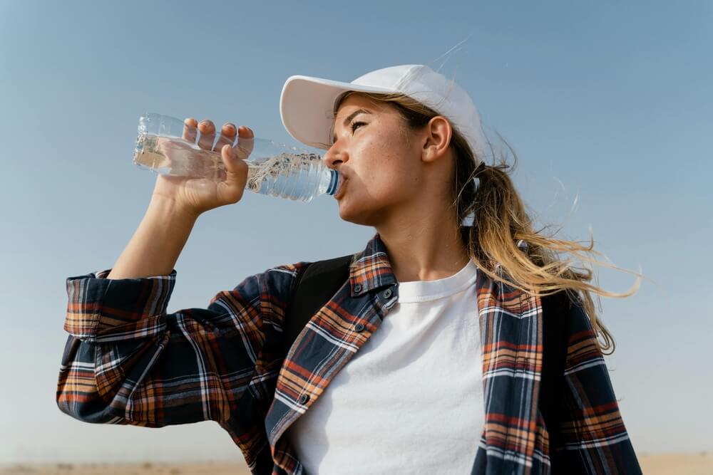 kobieta pijąca wodę z butelki