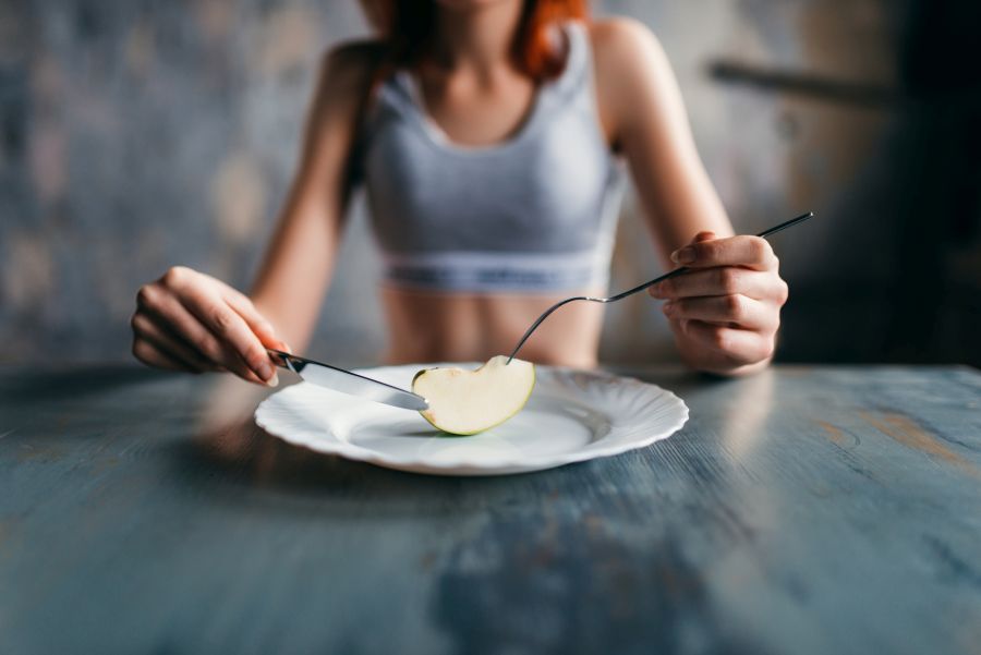 kobieta z kawałkiem jabłka na talerzu